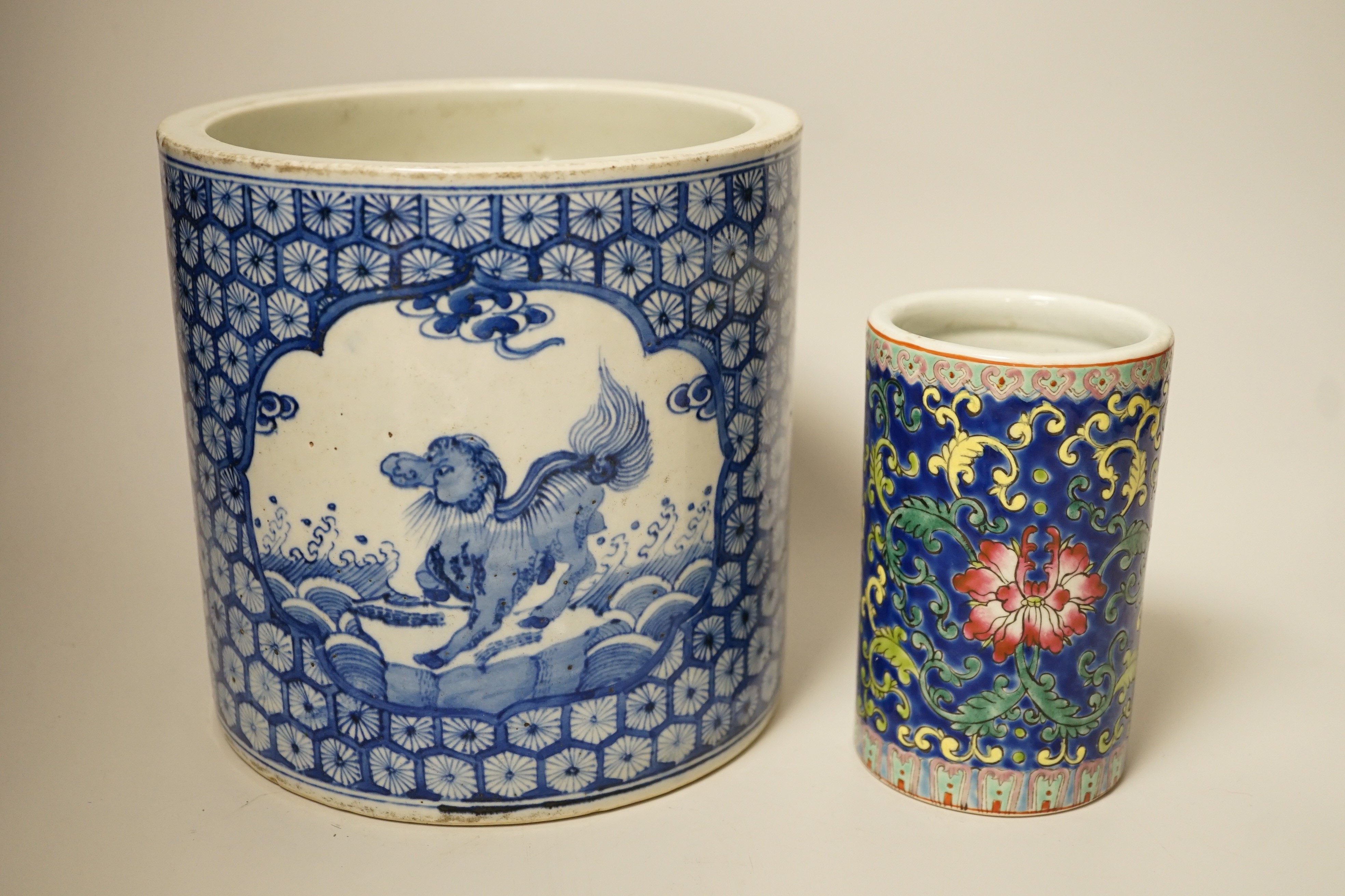 A Chinese blue and white brushpot, enamelled jar, brush pot, famille verte jar cover and a Japanese blue and white tea bowl and cover. Tallest 18cm